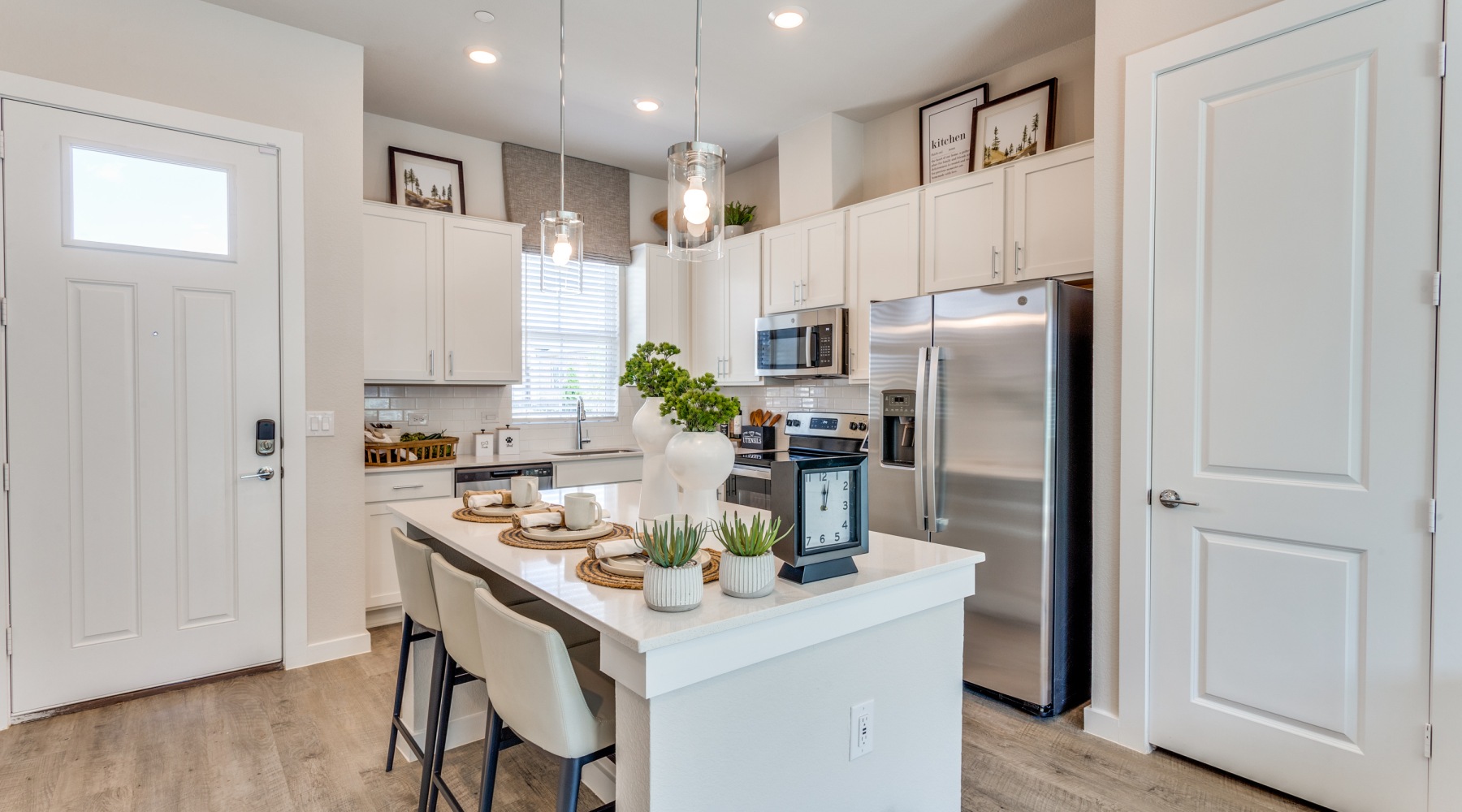 Call Cadia Grand Prairie your new home! Modern townhome kitchen with an island and stainless steel appliances at Cadia Grand Prairie