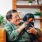 woman holding a dog while sitting on her living room couch