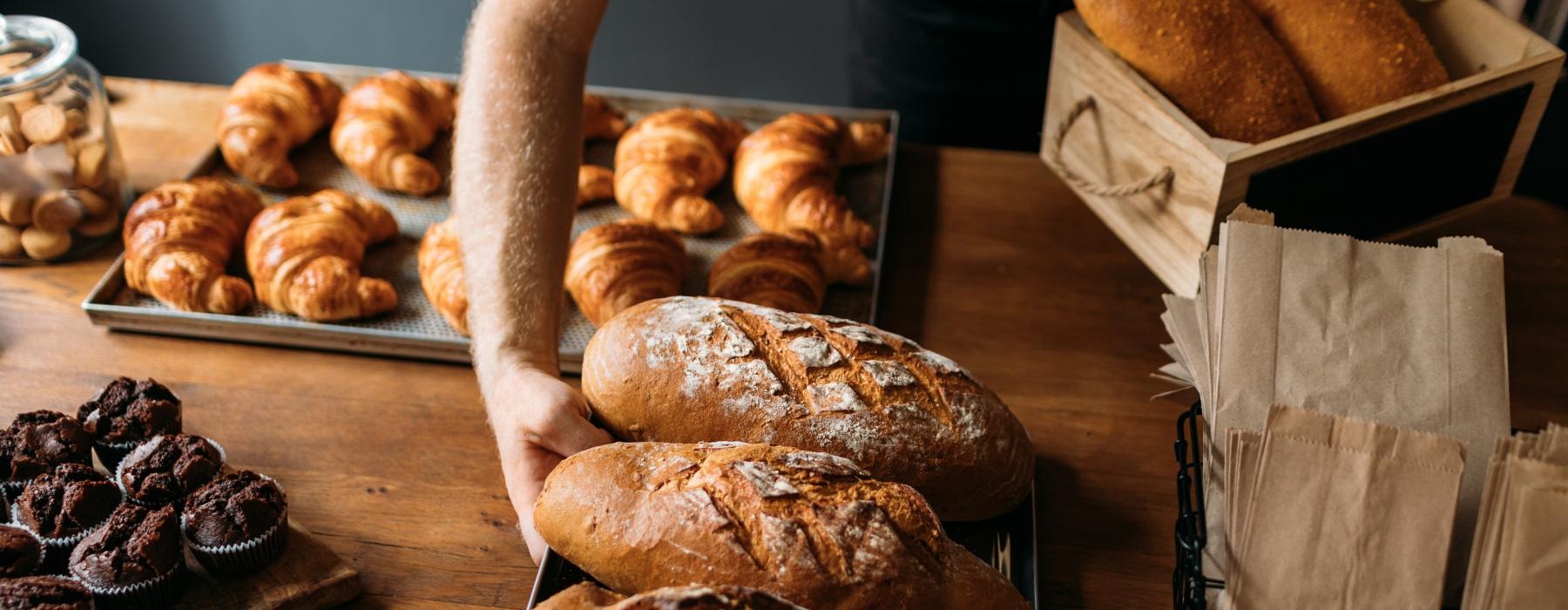 bakery table filled with pastries and breads